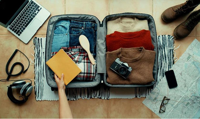 put clothes in a suitcase before going on a trip